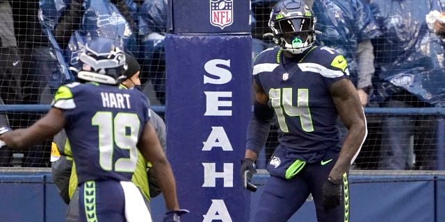 Fan, sfondo, cheer as Seattle Seahawks' DK Metcalf (14) tosses aside the ball after scoring on an 84-yard pass play against the New Orleans Saints during the first half of an NFL football game, Lunedi, Ott. 25, 2021, a Seattle.