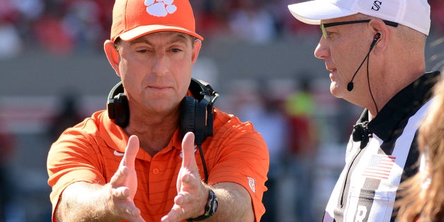 Clemson Tigers head coach Dabo Swinney (left) talks to an official during the first half against the North Carolina State Wolfpack at Carter-Finley Stadium.