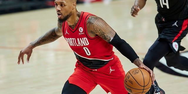 Portland Trail Blazers guard Damian Lillard drives to the basket in front of Los Angeles Clippers guard Terance Mann during the first half of a game in Portland, Oregon on October 29, 2021.