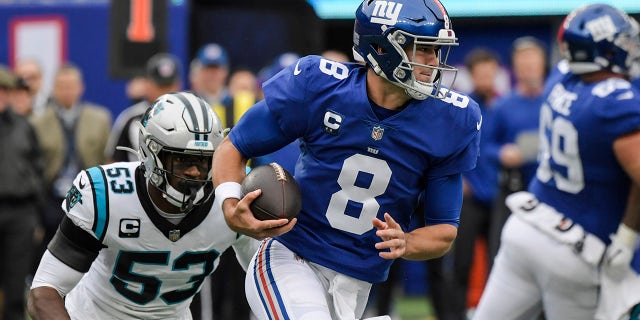 New York Giants quarterback Daniel Jones (8) rushes away from Carolina Panther Brian Burns (53) during the first half of a game Sunday, Oct. 24, 2021, in East Rutherford, N.J.