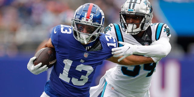 Dante Pettis (13) of the New York Giants runs with the ball as Sean Chandler (34) of the Carolina Panthers defends during the first half of a game at MetLife Stadium on Oct. 24, 2021 in East Rutherford, New Jersey.