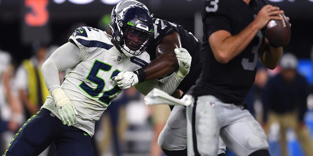 14 de agosto de 2021;  Paradise, Nevada, EUA;  O lado defensivo do Seattle Seahawks, Doral Taylor (52), e o quarterback do Las Vegas Riders, Nathan Peterman (3) pressionaram o segundo tempo no Allied Stadium.