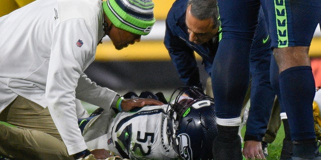 Seattle Seahawks defensive end Darrell Taylor (52) lays on the ground and is tended after being injured during the second half an NFL football game against the Pittsburgh Steelers, Sunday, Oct. 17, 2021, in Pittsburgh.