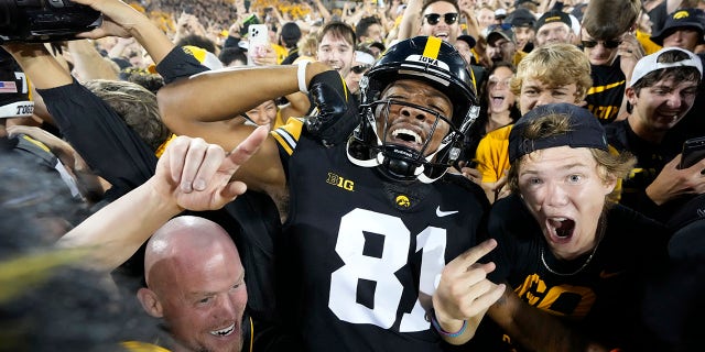 Iowa wide receiver Desmond Hutson (81) celebrates with fans on the field after Iowa beat Penn State 23-20, in an NCAA college football game, Saturday, Oct. 9, 2021, in Iowa City, Iowa.