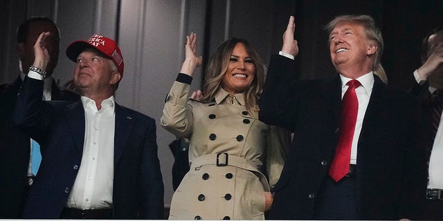 Former President Donald Trump and his wife Melania perform the tomahawk chop cheer before Game 4 of baseball's World Series between the Houston Astros and the Atlanta Braves Saturday, Oct. 30, 2021, in Atlanta.