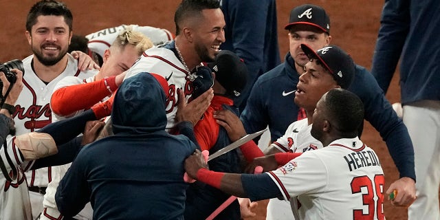Atlanta Braves' Eddie Rosario is congratulated by teammates after hitting the game winning RBI single during the ninth inning against the Los Angeles Dodgers in Game 2 of baseball's National League Championship Series Sunday, Oct. 17, 2021, in Atlanta. The Braves defeated the Dodgers 5-4 to lead the series 2-0 games.