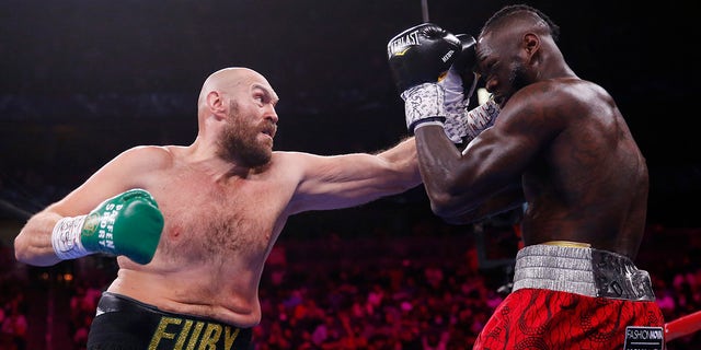 Tyson Fury of England hits Deontay Wilder during a heavyweight championship boxing match on Saturday, October 9, 2021 in Las Vegas. 