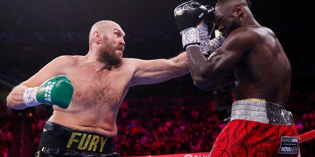 Tyson Fury of England hits Deontay Wilder during a heavyweight championship boxing match on Saturday, October 9, 2021 in Las Vegas. 