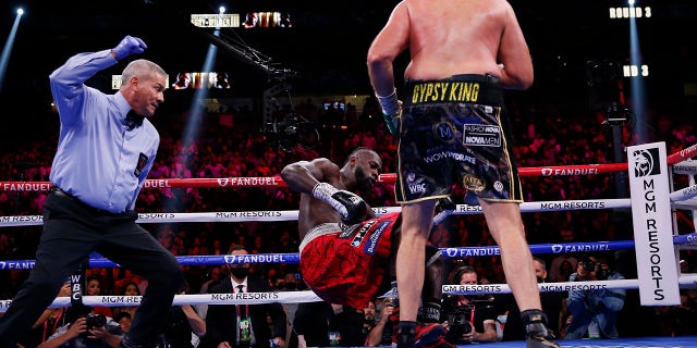 Tyson Fury, of England, knocks down Deontay Wilder in a heavyweight championship boxing match Saturday, Oct. 9, 2021, in Las Vegas.