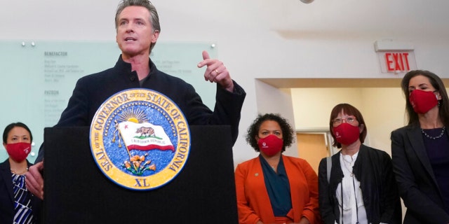 Gov. Gavin Newsom speaks at a news conference after receiving a Moderna COVID-19 vaccine booster shot at Asian Health Services in Oakland, Calif., Wednesday, Oct. 27, 2021. Also pictured are Assemblymember Mia Bonta, third from bottom right, Supervisor Wilma Chan and Oakland Mayor Libby Schaaf, right. (AP Photo/Jeff Chiu) 