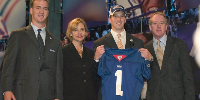 Eli Manning poses with a New York Giants jersey with his family during the 2004 NFL Draft at Madison Square Garden. Manning was selected No. 1 by the San Diego Chargers then traded to the New York Giants for Philip Rivers.