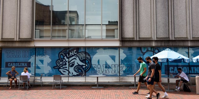 CHAPEL HILL, NC - AUGUST 18: Students walk through the campus of the University of North Carolina at Chapel Hill on August 18, 2020 in Chapel Hill, North Carolina. The school halted in-person classes and reverted back to online courses after a rise in the number of COVID-19 cases over the past week. (Photo by Melissa Sue Gerrits/Getty Images)