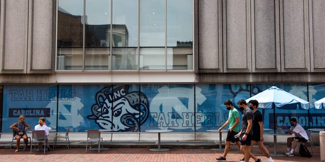 CHAPEL HILL, NC - AUGUST 18: Students walk through the campus of the University of North Carolina at Chapel Hill on August 18, 2020 in Chapel Hill, North Carolina. The school halted in-person classes and reverted back to online courses after a rise in the number of COVID-19 cases over the past week. (Photo by Melissa Sue Gerrits/Getty Images)