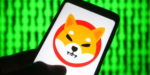 UKRAINE - 2021/06/03: In this photo illustration, a cryptocurrency Shiba Token $SHIB (Shiba Inu) logo is seen on a smartphone with a pc screen in the background.