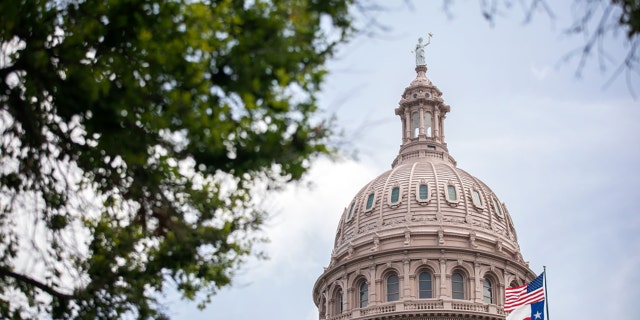 The U.S. and Texas flags wave outside the Texas Capitol on July 13, 2021 in Austin, Texas. (Photo by Montinique Monroe/Getty Images)