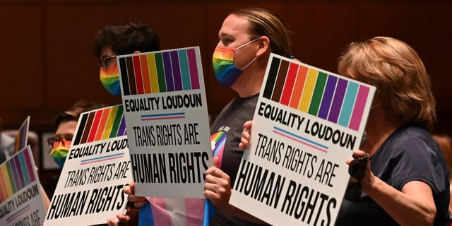 FILE - Supporters of Policy 8040 celebrate with signs as the transgender protection measures were voted into the school systems policies during a school board meeting at the Loudoun County Public Schools Administration Building on Aug. 11, 2021 in Ashburn, Va. (Photo by Ricky Carioti/The Washington Post via Getty Images)