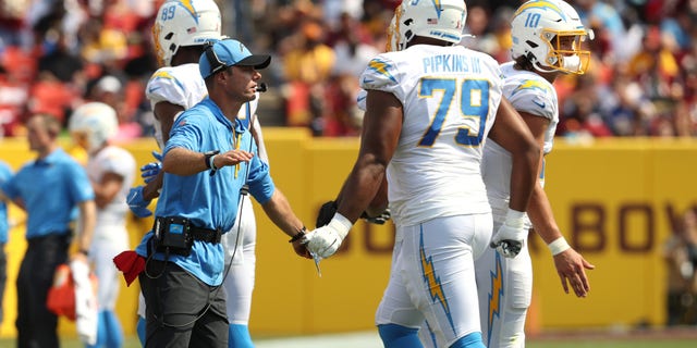 Head coach Brandon Staley of the Los Angeles Chargers high fives Trey Pipkins #79 during the first half against the Washington Football Team at FedExField on Sept. 12 in Landover, Maryland.