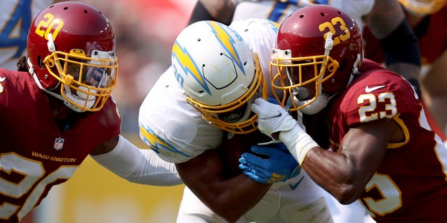 LANDOVER, MARYLAND - SEPTEMBER 12: Austin Ekeler #30 of the Los Angeles Chargers breaks a tackle from William Jackson #23 of the Washington Football Team at FedExField on September 12, 2021 in Landover, Maryland. (Photo by Patrick Smith/Getty Images)