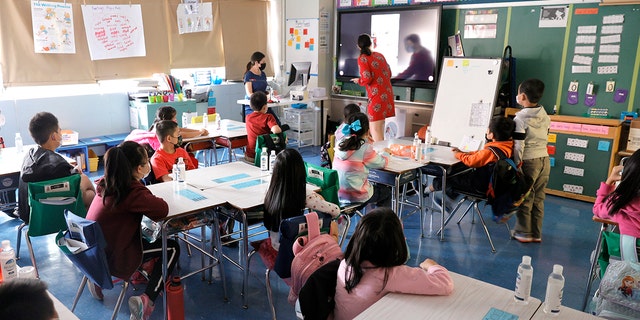 Co-teachers at Yung Wing School P.S. 124 Marisa Wiezel (who is related to the photographer), left, and Caitlin Kenny give a lesson to their masked students in their classroom on Sept. 27, 2021 in New York City.  