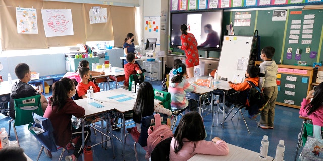 Co-teachers at Yung Wing School P.S. 124 Marisa Wiezel (who is related to the photographer), left, and Caitlin Kenny give a lesson to their masked students in their classroom on Sept. 27, 2021 in New York City.  