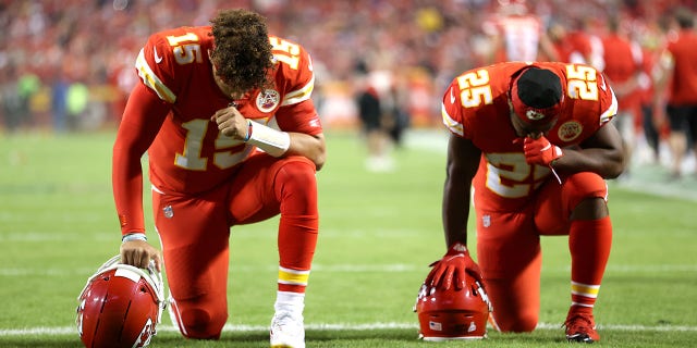 Patrick Mahomes #15 and Clyde Edwards-Helaire #25 of the Kansas City Chiefs take a knee prior to a game against the Buffalo Bills  at Arrowhead Stadium on Oct. 10, 2021 in Kansas City, Missouri.