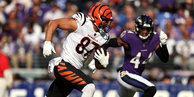 C.J. Uzomah (87) of the Cincinnati Bengals runs with the ball as Marlon Humphrey (44) of the Baltimore Ravens pursues during the first half in a game at M and T Bank Stadium Oct. 24, 2021 in Baltimore. (Photo by Patrick Smith/Getty Images)