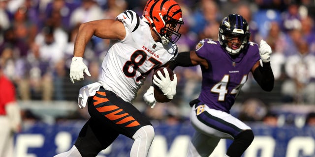 C.J. Uzomah (87) of the Cincinnati Bengals runs with the ball as Marlon Humphrey (44) of the Baltimore Ravens pursues during the first half in a game at M and T Bank Stadium Oct. 24, 2021 in Baltimore. (Photo by Patrick Smith/Getty Images)