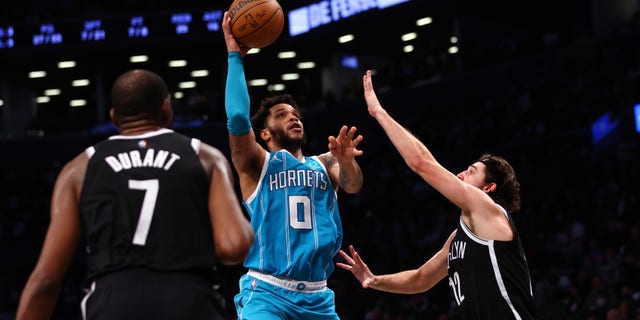 Miles Bridges #0 of the Charlotte Hornets attempts a shot as Kevin Durant #7 and Joe Harris #12 of the Brooklyn Nets defend during the second half of a game at Barclays Center on Oct. 24, 2021 in New York City. The Hornets defeated the Nets 111-95." (Photo by Rich Schultz/Getty Images)