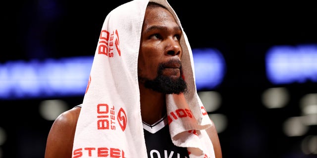 Kevin Durant #7 of the Brooklyn Nets looks on from the bench during a game against the Charlotte Hornets at Barclays Center on October 24, 2021 in New York City. The Hornets defeated the Nets 111-95.