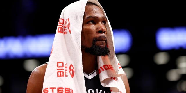 Kevin Durant #7 of the Brooklyn Nets looks on from the bench during a game against the Charlotte Hornets at Barclays Center on October 24, 2021 in New York City. The Hornets defeated the Nets 111-95.