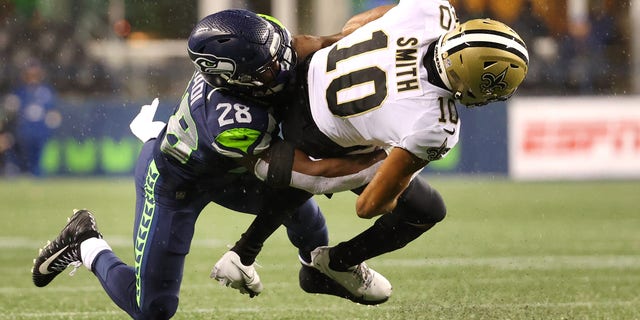 Seattle, Washington - 25 de octubre: New Orleans Saints Dre Quan Smith # 10 fue noqueado por Ugo Amadi # 28 de los Seattle Seahawks en la segunda mitad en Lumen Field, Seattle, el 25 de octubre de 2021.