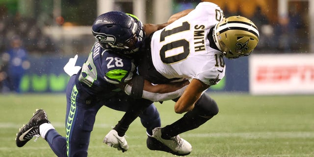 SEATTLE, WASHINGTON - OCTOBER 25: Tre'Quan Smith #10 of the New Orleans Saints is brought down by Ugo Amadi #28 of the Seattle Seahawks during the second half at Lumen Field on October 25, 2021 in Seattle, Washington.