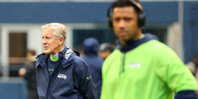 Coach Pete Carroll of the Seattle Seahawks looks on alongside Russell Wilson before the game against the New Orleans Saints at Lumen Field on Oct. 25, 2021, in Seattle, Washington.