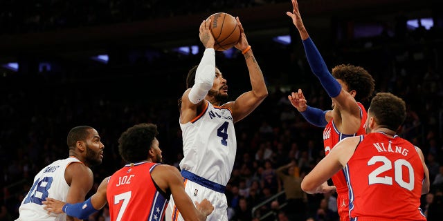 Derrick Rose (4) of the New York Knicks drives to the basket as Tobias Harris (12), Isaiah Joe (7), and Georges Niang (20) of the Philadelphia 76ers defend during the second half at Madison Square Garden Oct. 26, 2021 in New York City.