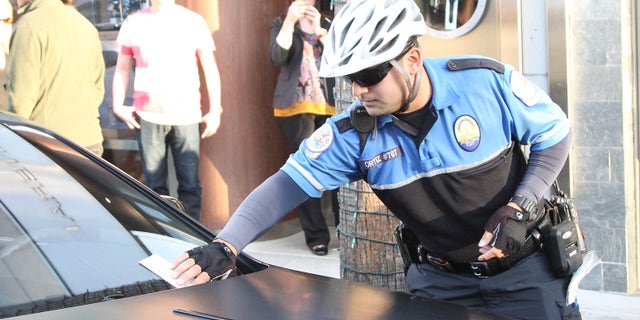 LOS ANGELES, CA - JANUARY 06: A traffic officer places a ticket on the car of Kim Kardashian on January 06, 2014 in Los Angeles, California. (Photo by Pixplus/Bauer-Griffin/GC Images)