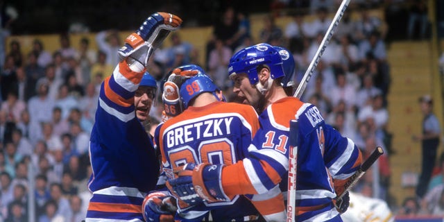 Jari Kurri #17 et Mark Messier #11 des Oilers d'Edmonton félicitent leur coéquipier Wayne Gretzky #99 après avoir marqué un but lors de la finale de la Coupe Stanley 1988 contre les Bruins de Boston en mai 1988 au Boston Garden de Boston. 