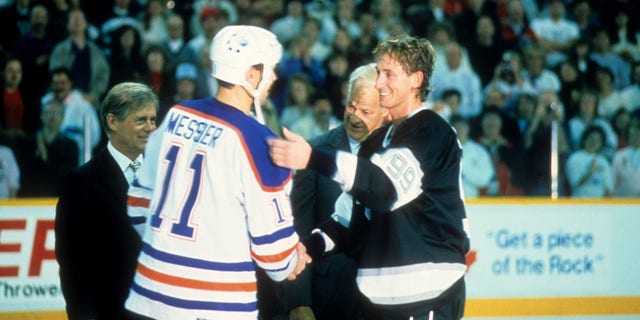 Mark Messier #11 des Oilers d'Edmonton félicite Wayne Gretzky #99 des Kings de Los Angeles après avoir marqué son 1851e point dans la LNH le 15 octobre 1989 au Northlands Coliseum à Edmonton, Alberta, Canada. 