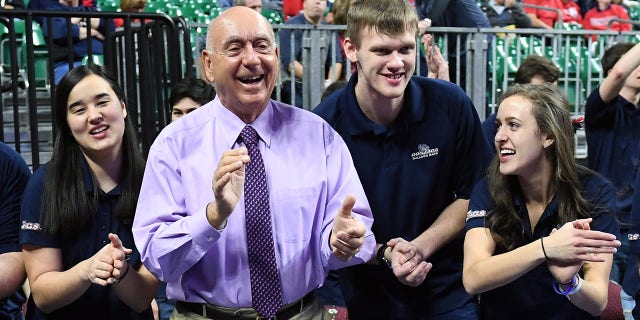 El atleta Dick Vitale (2do L) baila con miembros de los Gonzaga Bulldogs antes del partido del Campeonato de baloncesto Brigham Young Cougars de los Bulldogs en el Orleans Arena el 6 de marzo de 2018. Las Vegas, NJ  Los Bulldogs ganaron 74-54. 