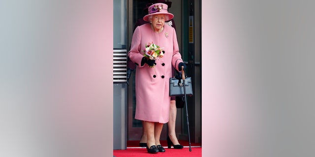 Queen Elizabeth II seen using a walking stick as she steps out of an elevator after attending the opening ceremony of the sixth session of the Senedd at The Senedd on October 14, 2021 in Cardiff, Wales.