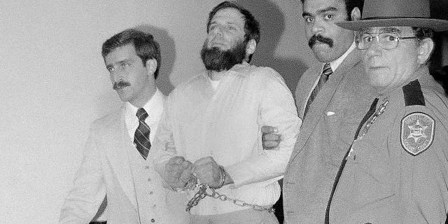 FILE - In this Nov. 23, 1981, file photo, law officials escort a handcuffed David Gilbert, second from left, from Rockland County Court in New City, N.Y. (AP Photo/David Handschuh, File)