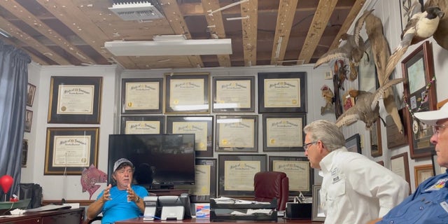 David Camardelle (D), Mayor of Grand Isle (left), speaks to local leaders in his office damaged by Hurricane Ida.