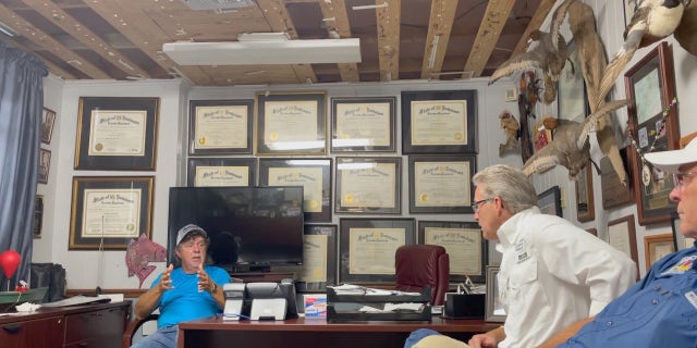 David Camardelle (D), Mayor of Grand Isle (left), speaks to local leaders in his office damaged by Hurricane Ida.