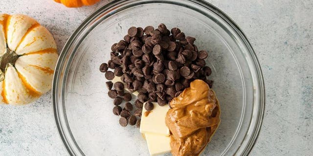 Kate Kasbee and American Licorice Company shared a sour punch Halloween muddy buddies recipe with Fox News. First, you'll need to combine chocolate chips, peanut butter, and butter in a microwave-safe bowl.