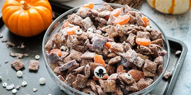 Gearing up for some Halloween treats? Whip up a batch of these festive muddy buddies — a medley of cereal with melted chocolate chips, peanut butter, Sour Punch candy, and more.