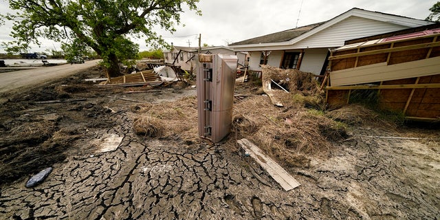 A casket that floated from its tombs during flooding from Hurricane Ida sits in a lawn of a destroyed home in Ironton, Louisiana, on Sept. 27.