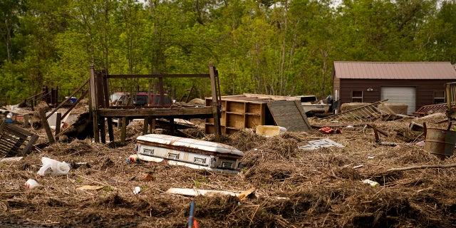 A displaced casket that floated from a cemetery during flooding from Hurricane Ida sits among displaced marsh grass and ruin in Ironton, La., on Sept. 27.