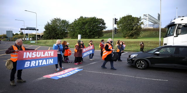 Activists from Isulate Britain block a roundabout at a junction on the M25 motorway as they protest in Thurrock, Britain on October 13.