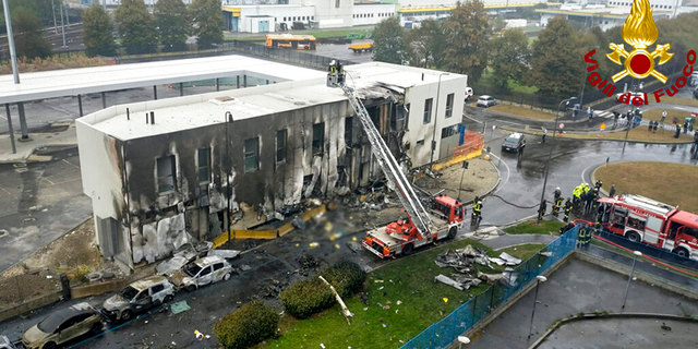 Firefighters work on the site of a plane crash, in San Donato Milanese suburb of Milan, Italy, Sunday, Oct. 3, 2021. 