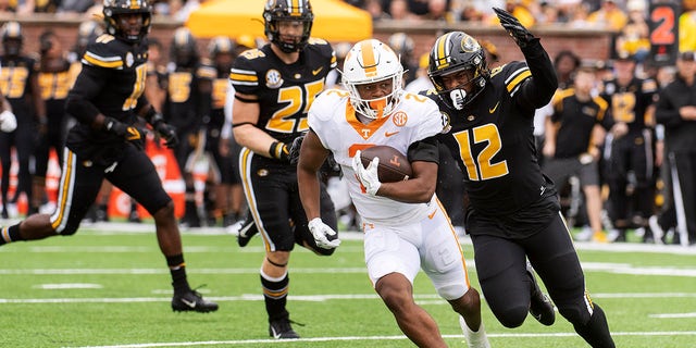 Tennessee running back Jabari Small, center, is chased by Missouri defensive back Shawn Robinson, right, and Blaze Alldredge, left, during the first half of an NCAA college football game Saturday, Oct. 2, 2021, in Columbia, Mo. 