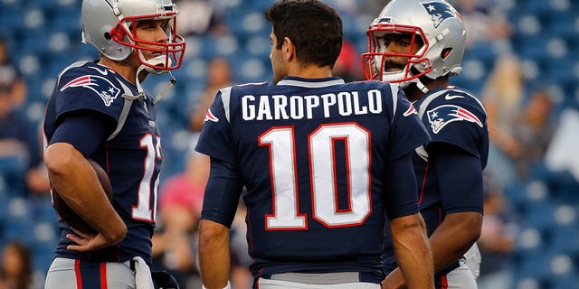 Jimmy Garoppolo (10), Jacoby Brissett (7) and Tom Brady (12) of the New England Patriots chat before a pre-season game with the New York Giants at Gillette Stadium on August 31, 2017 in Foxboro, Massachusetts.